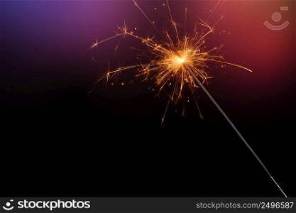 Sparkler burining glittering candle magic festive light on dark background. Christmas party sparkler or Bengal fire.