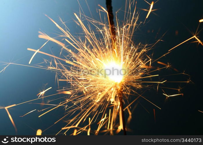 sparkler fire on blue macro background close up