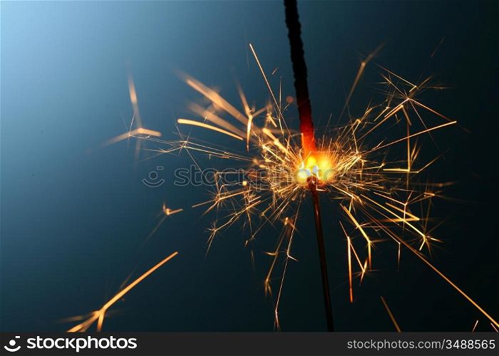 sparkler fire on blue macro background close up
