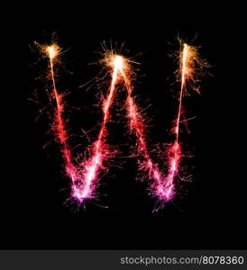 Sparkler firework light alphabet W at night background