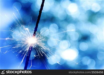 sparkler on blue bokeh background macro close up