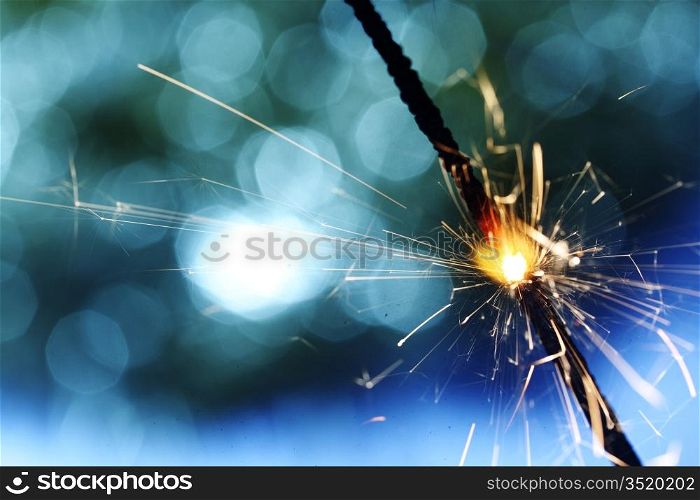 sparkler on blue bokeh background macro close up