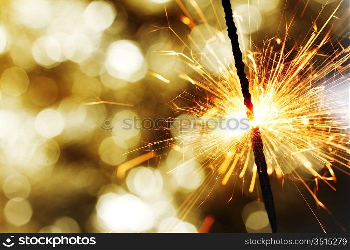 sparkler on gold bokeh background macro close up