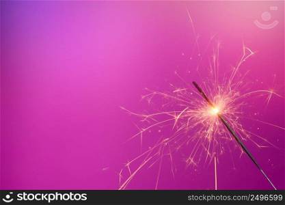Sparkler on pink background. Shiny bengal fire with copy-space.