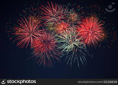 Sparkling red green yellow fireworks over starry sky. Sparkling red green yellow celebration fireworks over starry sky. Independence Day, 4th of July, New Year holidays salute background.