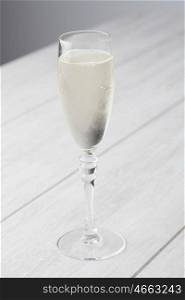 Sparkling white wine glass on a gray wooden table&#xA;
