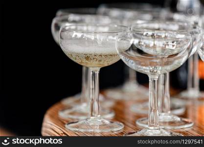 sparkling wine, champagne in glasses on the wooden table on black background in the restaurant. selective focus.. sparkling wine, champagne in glasses on the wooden table on black background in the restaurant. selective focus