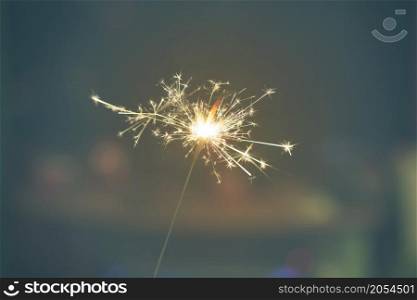 Sparks from hand cold fireworks dim background
