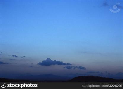 Sparsely Clouded Clear Blue Sky Over Mountains At Dusk