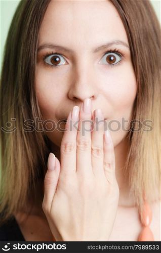 Speak no evil concept. Surprised woman face wide eyed covering her mouth with hand