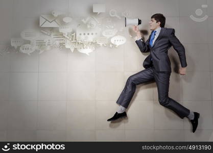 Speaker man. Young businessman running with megaphone in hand