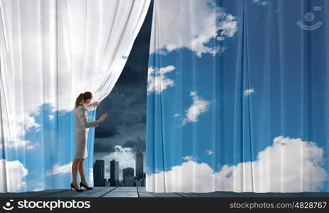 Speaker on stage. Young businesswoman opening stage curtain to another reality