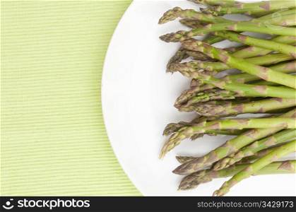 Spears of Fresh Uncooked Asparagus on White Plate