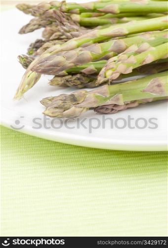 Spears of Fresh Uncooked Asparagus on White Plate - Shallow Depth of Field