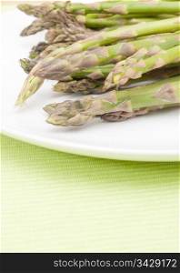 Spears of Fresh Uncooked Asparagus on White Plate - Shallow Depth of Field