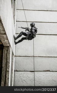 Spec ops police officer SWAT during rope exercises with weapons. tactical rappeling