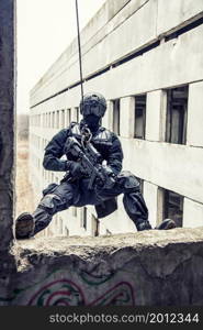 Spec ops police officer SWAT during rope exercises with weapons. tactical rappeling