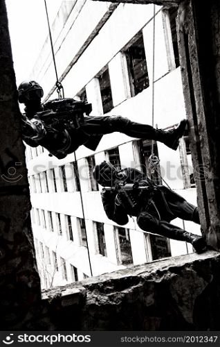 Spec ops police officers SWAT during rope exercises with weapons. tactical rappeling