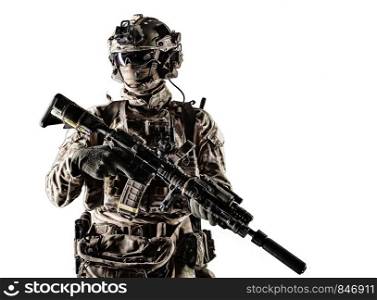 Special forces fighter in battle uniform and helmet with radio headset, face mask and ballistic glasses, standing with equipped laser sight and silencer service rifle studio portrait isolated on white. Modern army armed ranger isolated studio portrait