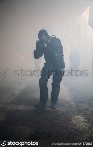 Special forces operator in black uniform in the smoke. assault in the smoke