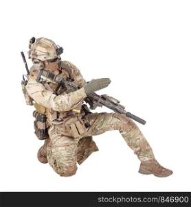 Special forces sergeant, battle squad leader in camo uniform, helmet with radio headset, armed rifle standing on knee, pointing direction, giving orders to teammates studio shoot isolated on white. Army sergeant pointing attack direction with palm