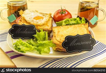 Special french sandwiches for men and women Delicious meal with french sandwiches called croque madame and croque monsieur, with labels for each one.