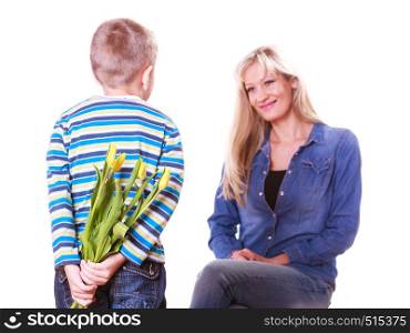 Special occasions holiday and mother day. Young boy prepare surprise gift flowers hold tulips behind back mother sit smiling.. Little boy with mother hold flowers behind back.