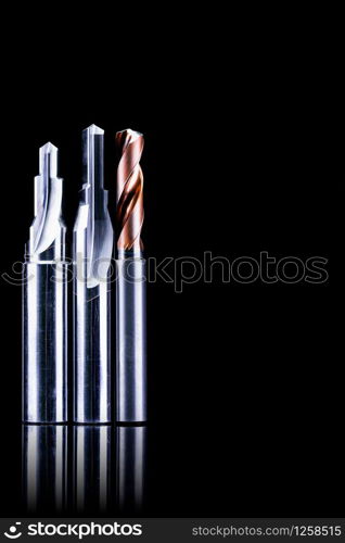 Special tools isolated on dark background. Made to order special tools. Coated step drill and reamer detail. HSS cemented carbide. Carbide cutting tool for industrial applications. Engineering tools.