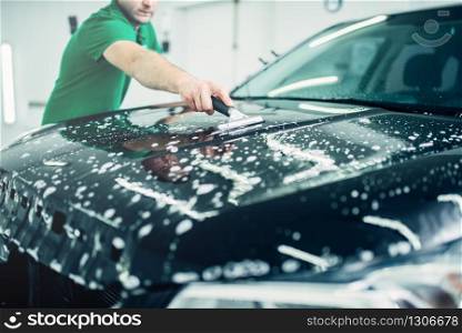 Specialist prepares car for protect against chips and scratches. Paint protection. Protective coating. Specialist prepares car for protect against chips