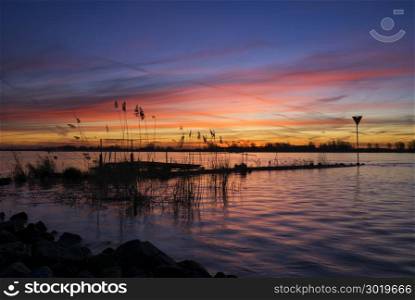 Spectacular sunrise above the river Merwede near Boven-Hardinxveld in the dutch region Alblasserwaard. Sunrise above the river Merwede