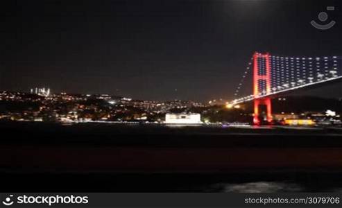 Spectacular view from a boat sailing under Istanbul&acute;s bridge at night