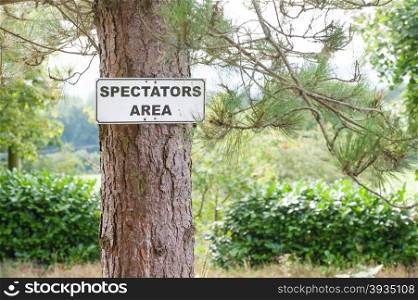 spectator viewing area sign on a pine tree
