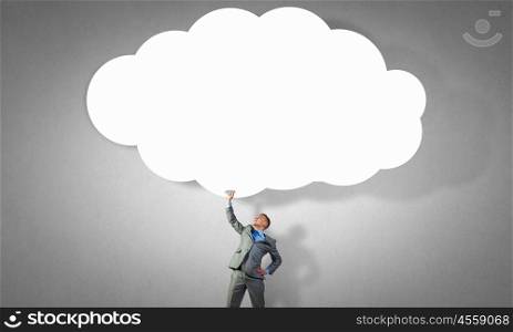 Speech cloud. Young businessman holding speech cloud above head. Place for your text