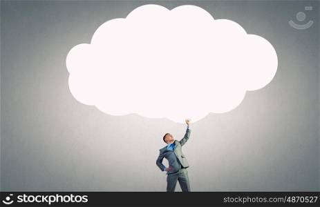Speech cloud. Young businessman holding speech cloud above head. Place for your text