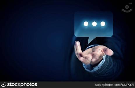 Speech icon in palm. Close up of businessman hand holding chat icon