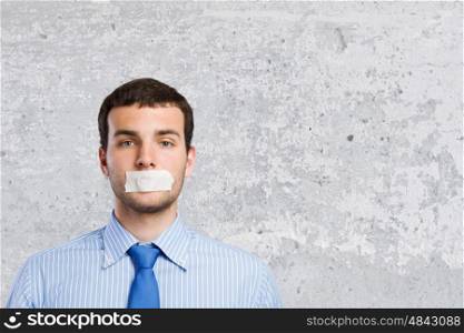 Speechless businessman. Young handsome businessman with adhesive tape on mouth