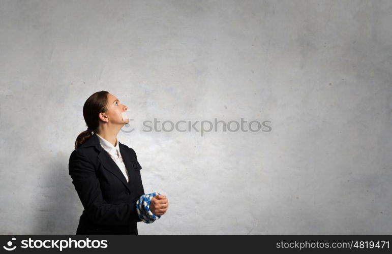 Speechless woman with tired hands. Young businesswoman with tape on mouth and tired hands