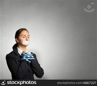 Speechless woman with tired hands. Young businesswoman with tape on mouth and tired hands
