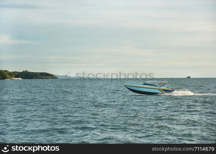 speed boat ship at sea on a background of clouds blue sky near island.