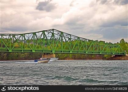 Speed Boats Under a Bridge