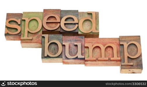 speed bump phrase in vintage wood letterpress printing blocks, stained by color inks, isolated on white
