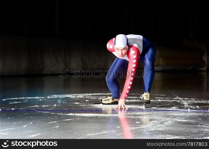 Speed skater at the starting line on an indoor ice rink