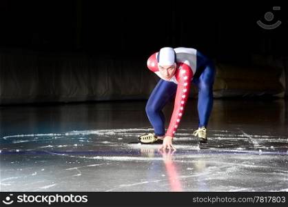 Speed skater at the starting line on an indoor ice rink