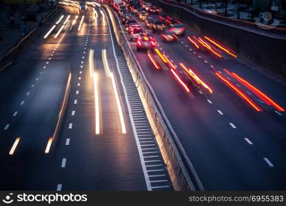 Speed Traffic - light trails on motorway highway at night, long exposure abstract urban background. Speed car traffic. Light trails on highway at night, long exposure abstract urban background