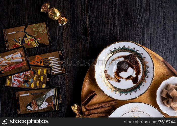 spelling coffee plate with coffee grounds and Tarot cards served at dark wooden table. devination concept