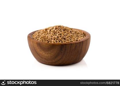 Spelt grain (dinkel wheat) in wooden bowl isolated on white background
