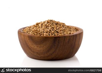 Spelt grain (dinkel wheat) in wooden bowl isolated on white background