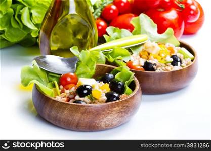 spelt salad with tomatoes and olives on white background