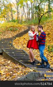 Spending time with loved ones. Romantic dates in autumnal park. Affection and feelings. Frendship and love. Young couple meet at park having fun on romantic date. Man hold woman in arms hug.. Romantic pair meet in park standing on stairs.