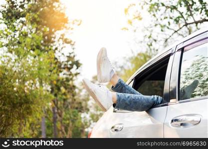 Spending weekend in roadtrip car vacation concept. Woman shoes out of car windows in car above the clouds. Conceptual freedom, travel and holidays image with copy space.